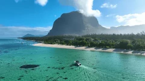 Bateau traversant le lagon turquoise au pied du Morne Brabant à Maurice